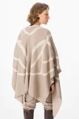 Ruana de tejido de punto con diseño geométrico abstracto en contraste. Presenta una caída fluida y abierta, ideal para superponer sobre otras prendas.