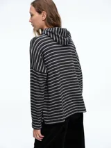 Buzo tejido de punto color negro, con capucha integrada, mangas largas y tajos laterales en el ruedo.