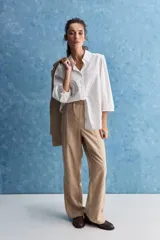 Camisa blanca de algodón, de calce relajado, con cuello camisero, frente abotonado y mangas largas abullonadas.