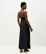 Vestido midi evasê marrón con breteles finos, escote corazón y corte en la cintura. Presenta silueta fluida con caída amplia y bolsillos laterales.