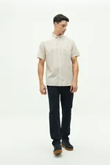 Camisa de manga corta confeccionada en mezcla de lino y algodón, con cuello camisero, cierre frontal de botones y bolsillo en el pecho con logo bordado.