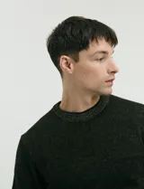 Sweater de punto con cuello redondo, manga larga y puños y ruedo acanalados. Presenta un diseño jaspeado en tonos oscuros.