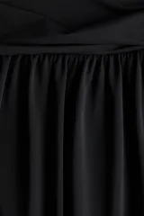 Pollera midi de punto color negro con diseño de bajo globo que crea una silueta abullonada. Cuenta con una cintura ancha elastizada y frunces.