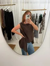 Blusa marrón sin mangas confeccionada en lino, con corte acinturado y cuello amplio.