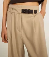 Pantalón de vestir color beige, de corte recto, con trabillas en la cintura y cinturón incorporado.