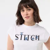 Remera corta blanca con diseño estampado de Stitch en el pecho y letras decorativas.