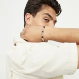 Pulsera elástica con cuentas de aleación de metales bañadas en plata y cuentas de madera.