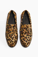 Mocasines de cuero con textura de pelo y estampado de leopardo, con diseño clásico de lengüeta decorativa y costuras frontales.