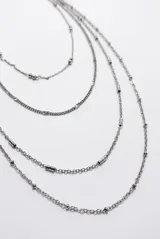 Collar de múltiples hilos de cadenas doradas con detalles de cuentas y eslabones texturizados.