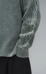 Sweater de cuello redondo con diseño de tejido texturizado en color verde y blanco. Presenta un calce relajado y terminaciones en punto rib en el cuello.