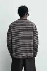 Jersey de punto con diseño de rayas horizontales en tonos marrón y gris, de corte relajado, cuello redondo y manga larga con terminaciones en rib.
