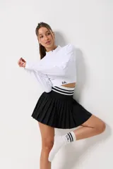 Pollera tableada de color negro con cintura elástica ancha en contraste, decorada con dos líneas horizontales blancas.