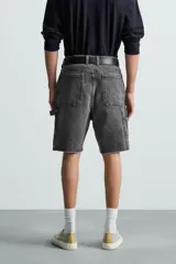 Bermuda relaxed fit confeccionada en tejido de algodón con efecto lavado. Presenta un diseño de cinco bolsillos, bolsillo multifunción en la pernera y tira lateral de estilo carpintero. Cuenta con cierre frontal con cremallera y botón.