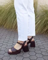 Sandalias de cuero color chocolate con textura símil serpiente, plataforma delantera, taco ancho y tira ajustable con hebilla en el talón.