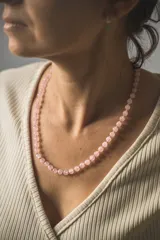 Collar de cuentas de cuarzo rosa de 6mm de diámetro, con separadores de hilo rosado y cierre de mosquetón de acero hipoalergénico con baño dorado.