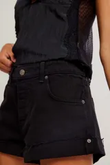 Short de denim negro de tiro medio y calce entallado, con cierre de botones a la vista, cinco bolsillos y ruedo con dobladillo vuelto.