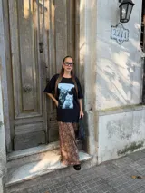 Conjunto compuesto por un remerón negro de algodón con estampa fotográfica frontal y una pollera midi de satén con estampado animal print de leopardo.