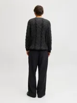 Sweater de punto con manga larga, cuello redondo y fit relajado. Presenta un diseño de tejido con textura acanalada y trenzada, puños y ruedo acanalados.