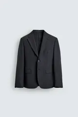 Blazer de corte regular fit confeccionado en tejido técnico y transpirable de color negro, con cuello de solapas de muesca, cierre frontal de un botón y bolsillos con solapa en la cadera.