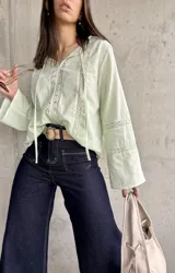 Blusa verde agua con detalles de encaje, mangas largas acampanadas y lazos en el escote.