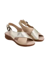 Sandalias de cuero con diseño de tiras cruzadas, una en tono dorado metalizado y otra en tono beige. Cuenta con cierre de hebilla lateral y suela de goma con textura tipo corcho.