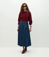 Pollera midi de corte evasé confeccionada en denim azul oscuro. Presenta recortes verticales, cintura alta con trabillas y cinturón desmontable del mismo tejido. Cuenta con cierre trasero oculto.