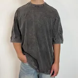 Remera oversize de algodón pesado con efecto de lavado snow que le otorga un tono gastado. Presenta cuello redondo, mangas cortas con costuras visibles y un corte amplio.