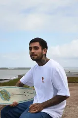 Remera celeste de algodón con estampa rectangular en la espalda que representa un paisaje de bosque con montañas, árboles y el sol. Incluye la frase 'Time to recreate'.