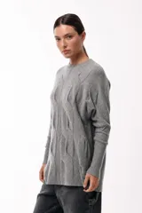 Sweater de punto con textura geométrica, de calce relajado, cuello redondo y mangas largas con puños ajustados.