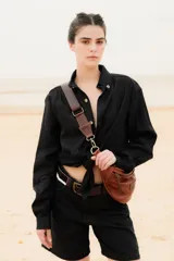 Camisa de lino color negro, de corte clásico con cuello camisero y cierre frontal de botones. Presenta un bordado sutil en el pecho.