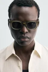 Camisa de hombre de corte relajado (relaxed fit) en tejido de mezcla de algodón y viscosa, color beige claro con finas rayas verticales. Presenta cuello italiano y manga larga con puño abotonado.