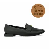 Zapato tipo mocasín de cuero negro con textura granulada, taco bajo cuadrado y detalle metálico dorado en el empeine.
