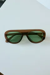 Lentes de sol con armazón de policarbonato color marrón traslúcido y diseño envolvente de una sola pieza.