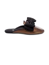 Sandalia mule color bronce con punta fina y lazo negro decorativo.