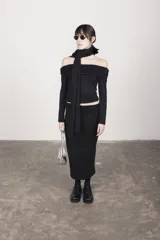 Top negro de jersey con escote bardot y mangas largas.