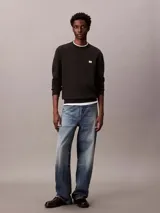 Buzo de algodón negro Calvin Klein, de cuello redondo, mangas largas y calce clásico. Presenta un pequeño parche con el monograma de la marca en el pecho y puños con ribete acanalado.