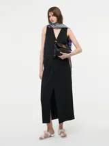 Falda maxi color marrón, con diseño pinzado en la cintura y un tajo delantero central que aporta movimiento.