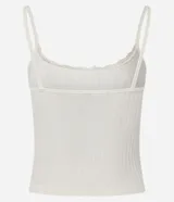 Blusa de tirantes finos confeccionada en poliamida seamless con textura acanalada. Presenta escote redondo decorado con encaje y una pequeña moña central.