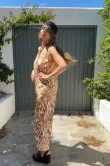 Mono largo de fibrana color camel con estampado abstracto en blanco, breteles finos y corte palazzo.