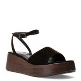 Sandalias de plataforma tipo zueco con tira ancha y pulsera ajustable al tobillo, confeccionadas en material textil de textura aterciopelada en color marrón, con base de plataforma efecto madera.