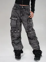 Pantalón cargo de jean con efecto lavado, corte baggy fit y tiro alto. Presenta múltiples bolsillos laterales con solapa y cierre de botón, además de detalles de ajuste en los tobillos.
