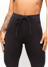 Calza negra de poliamida y elastano, con cintura alta y elástico interno.