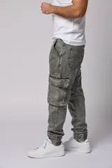 Pantalón jean gris claro, estilo jogger, con bolsillos cargo laterales y puños elásticos en los tobillos.