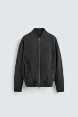 Chaqueta tipo bomber de punto compacto con efecto lavado, cuello subido, manga larga y cierre frontal con cremallera. Presenta bolsillos de vivo en la cadera y acabados en rib.