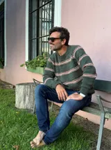 Sweater de punto con cuello redondo, diseño de rayas horizontales en tonos oscuros sobre base clara, de manga larga y calce cómodo.