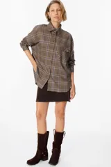 Camisa de corte oversize con estampado de cuadros, cuello clásico, cierre frontal con botones y bolsillo en el pecho.