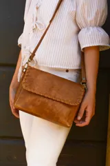 Bandolera de cuero color camel con correa larga regulable.