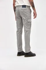 Pantalón cargo de gabardina en color gris, con corte standard slim. Presenta bolsillos laterales y bolsillos cargo con solapa y botones en los muslos.