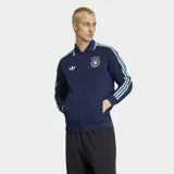 Campera deportiva Adidas de la selección de Alemania, color azul marino con detalles en celeste. Presenta cuello tipo polo, cierre frontal, bolsillos laterales y las icónicas tres tiras de la marca en las mangas. Incluye el logo del Trifolio y el escudo de la federación alemana en el pecho.