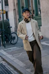 Blazer de corte recto y diseño minimalista, confeccionado en tejido de paño suave color beige. Presenta cuello con solapas clásicas, cierre frontal con un solo botón y dos bolsillos delanteros con solapa.